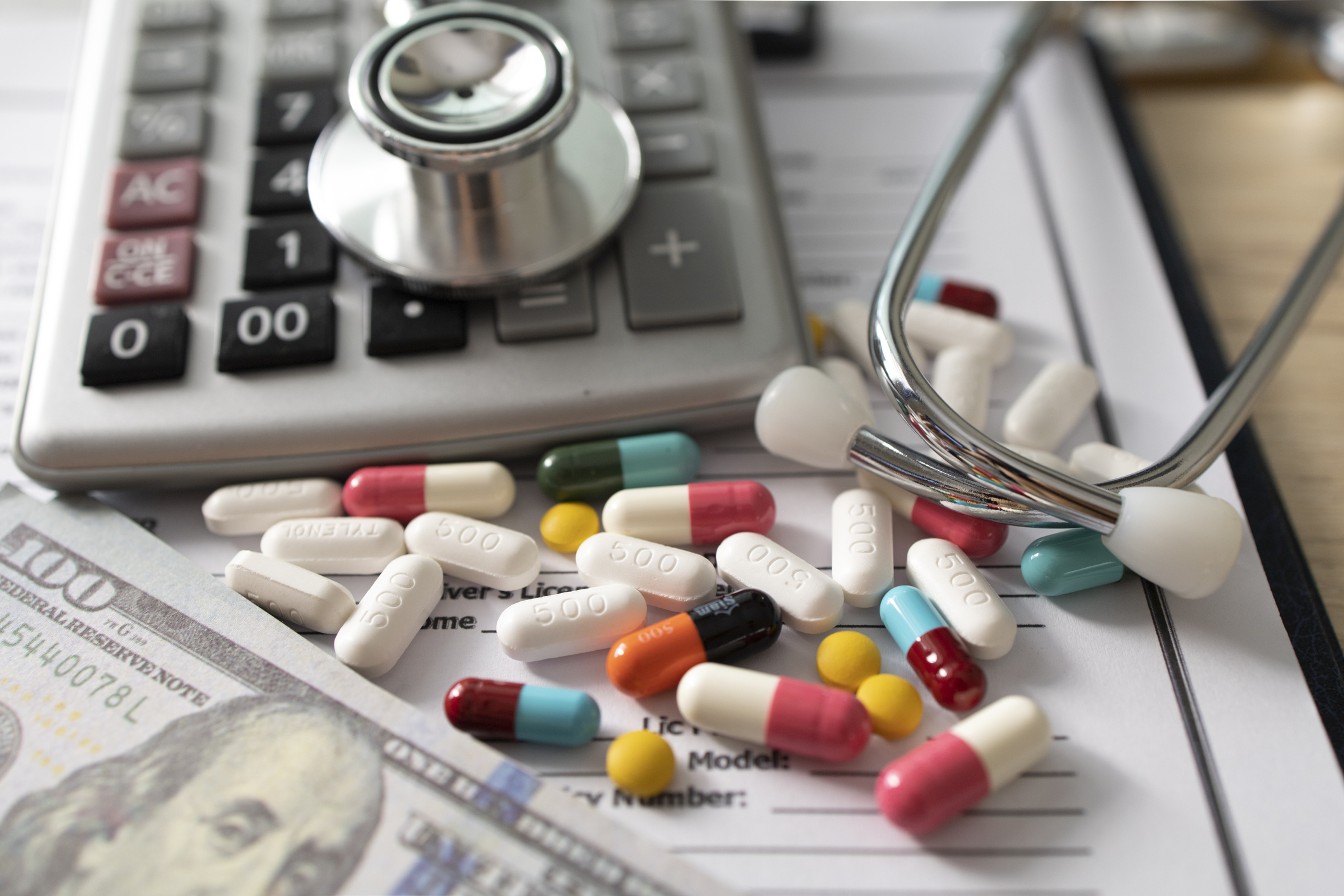 Image of pills next to a calculator and a stethoscope