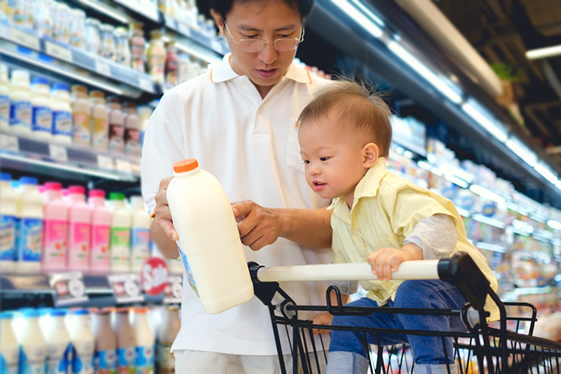 Asian Father & Cute little 18 months old toddler boy child choosing milk product in grocery store.