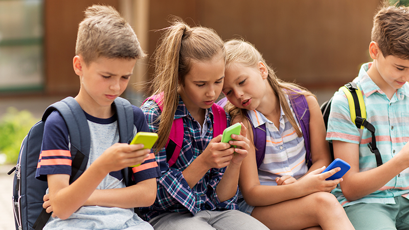 children looking at cell phone