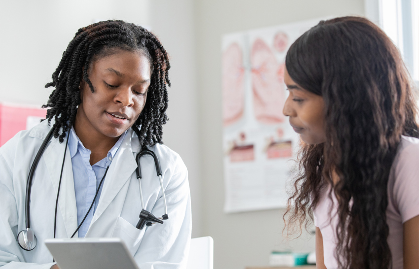 healthcare professional uses tablet with patient