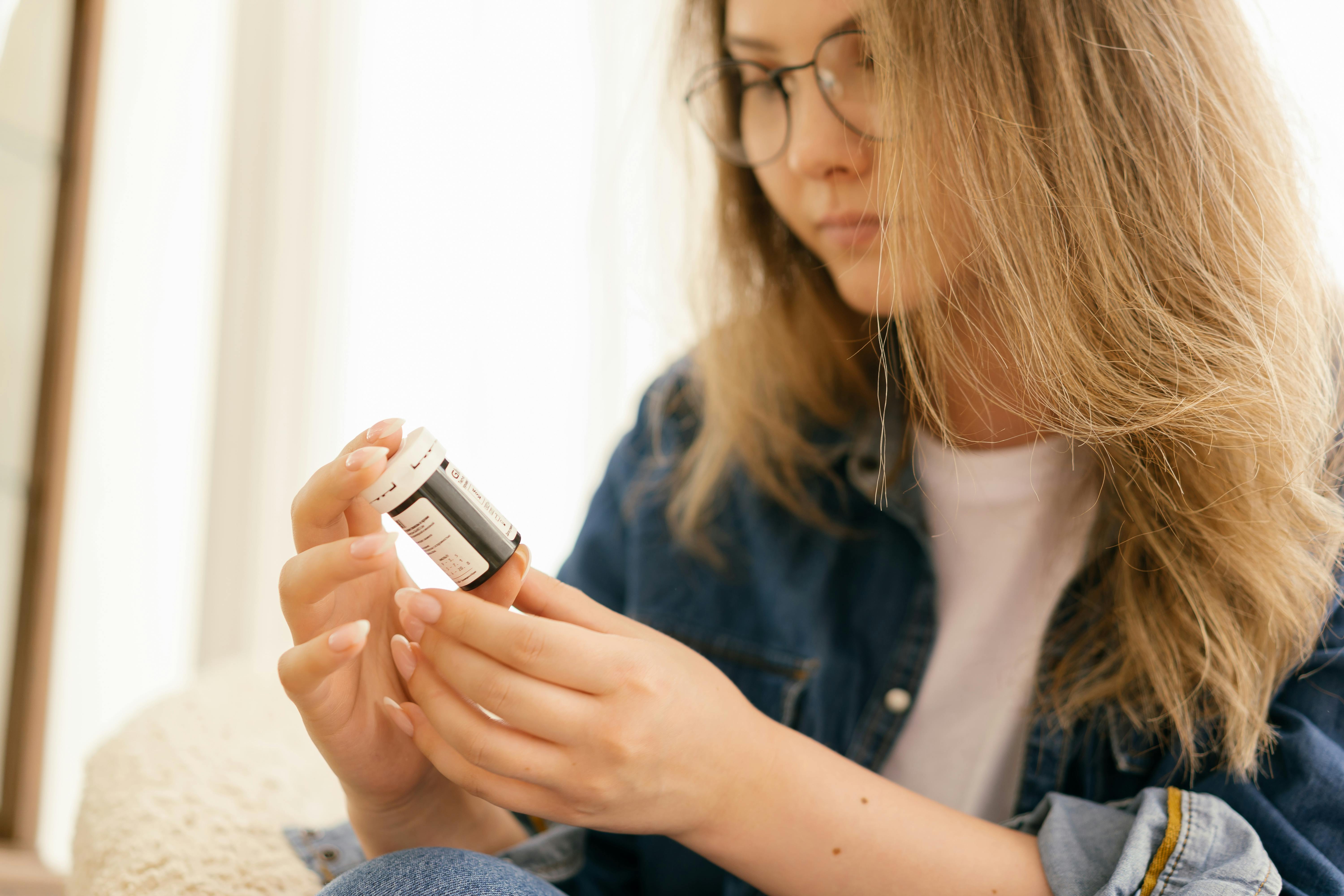 woman looking at prescription bottle