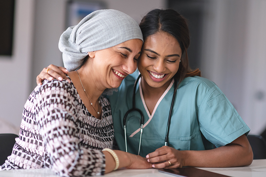 Woman being comforted by doctor. Both have smiles on face.