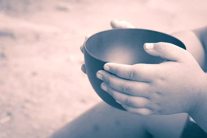 child's hands holding empty bowl