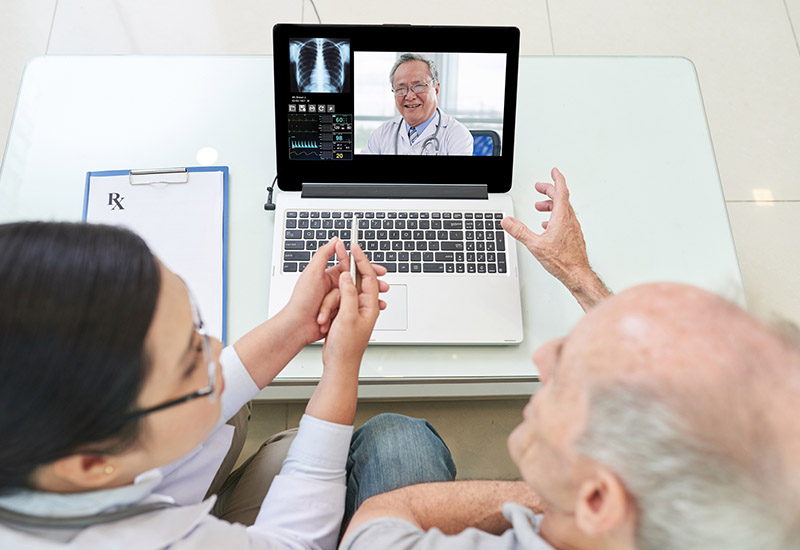 man and woman looking at doctor on a computer