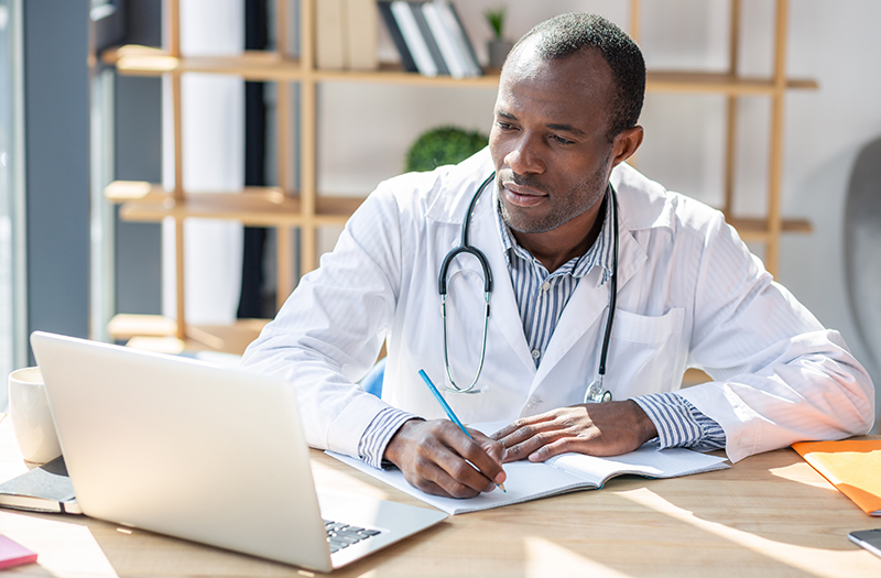 physician learning on a laptop 