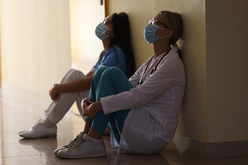tired medical staff leaning on wall