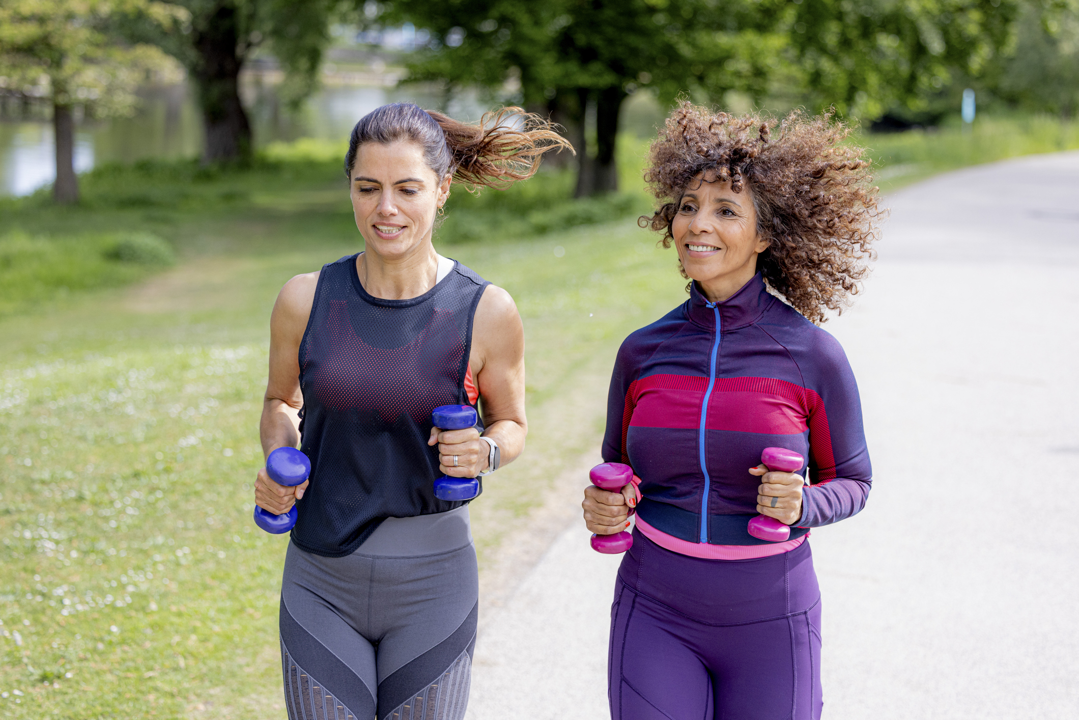 Two women jogging with weights