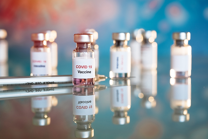 vaccine bottles on a table with needle