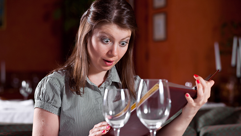 Woman looking at menu- surprised by calorie count