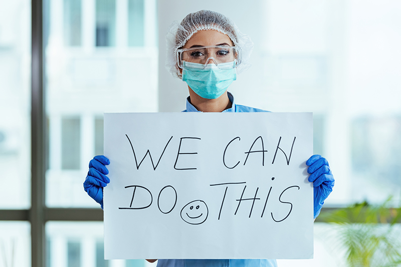 Woman holding "we can do it" sign