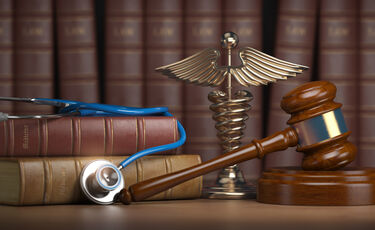 books, gavel, stethoscope and Rod of Asclepius