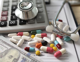 Image of pills next to a calculator and a stethoscope