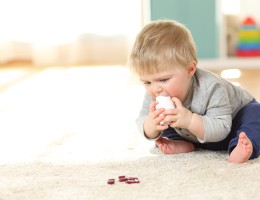 Baby in danger playing with a bottle of medicines