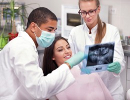 2 dentist looking at x-ray with patient