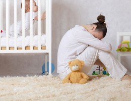 Mother depressed by baby in crib.