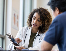 Female Doctor Uses Tablet to Show X-Ray to Patient