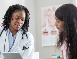 healthcare professional uses tablet with patient