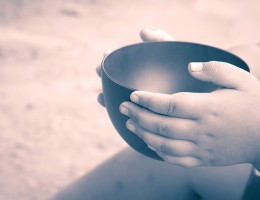 child's hands holding empty bowl