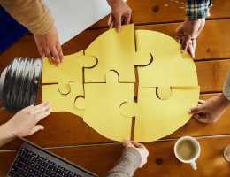 Above view of unrecognizable creative team cooperation while making light bubble of puzzles at casual office.