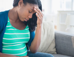 pregnant woman touching her forehead