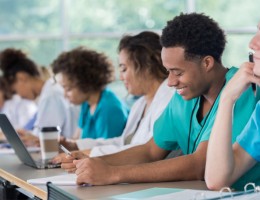 diverse pre med students take notes during class