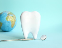 White tooth with dental instruments on a blue background