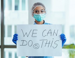 Woman holding "we can do it" sign